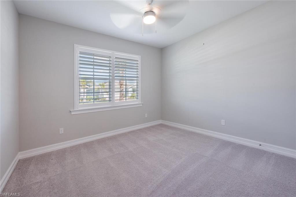388 Grace Bay Lane Naples, FL 34114 - Photo 15 of 39 Empty room featuring light carpet and ceiling fan