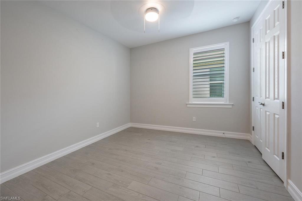 388 Grace Bay Lane Naples, FL 34114 - Photo 18 of 39 Unfurnished bedroom with a closet, light wood-style floors, and ceiling fan