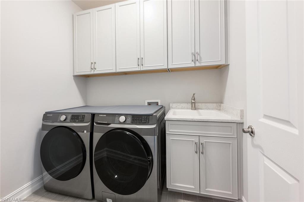 388 Grace Bay Lane Naples, FL 34114 - Photo 19 of 39 Washroom with washing machine and dryer and cabinet space