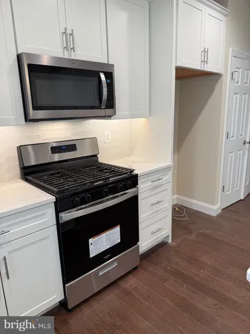 an empty room with wooden floor and chandelier fan