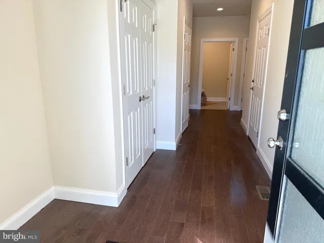 a view of a kitchen with fridge and wooden floor