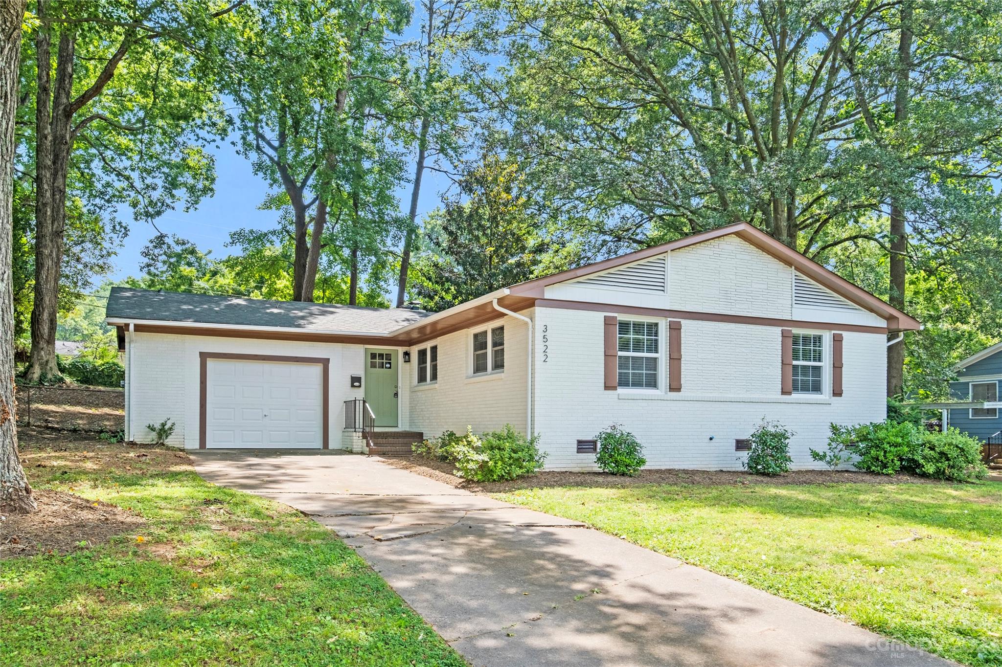 3522 Enfield Road Charlotte, NC 28205 - Photo 1 of 32 a view of a white house next to a yard and a large tree