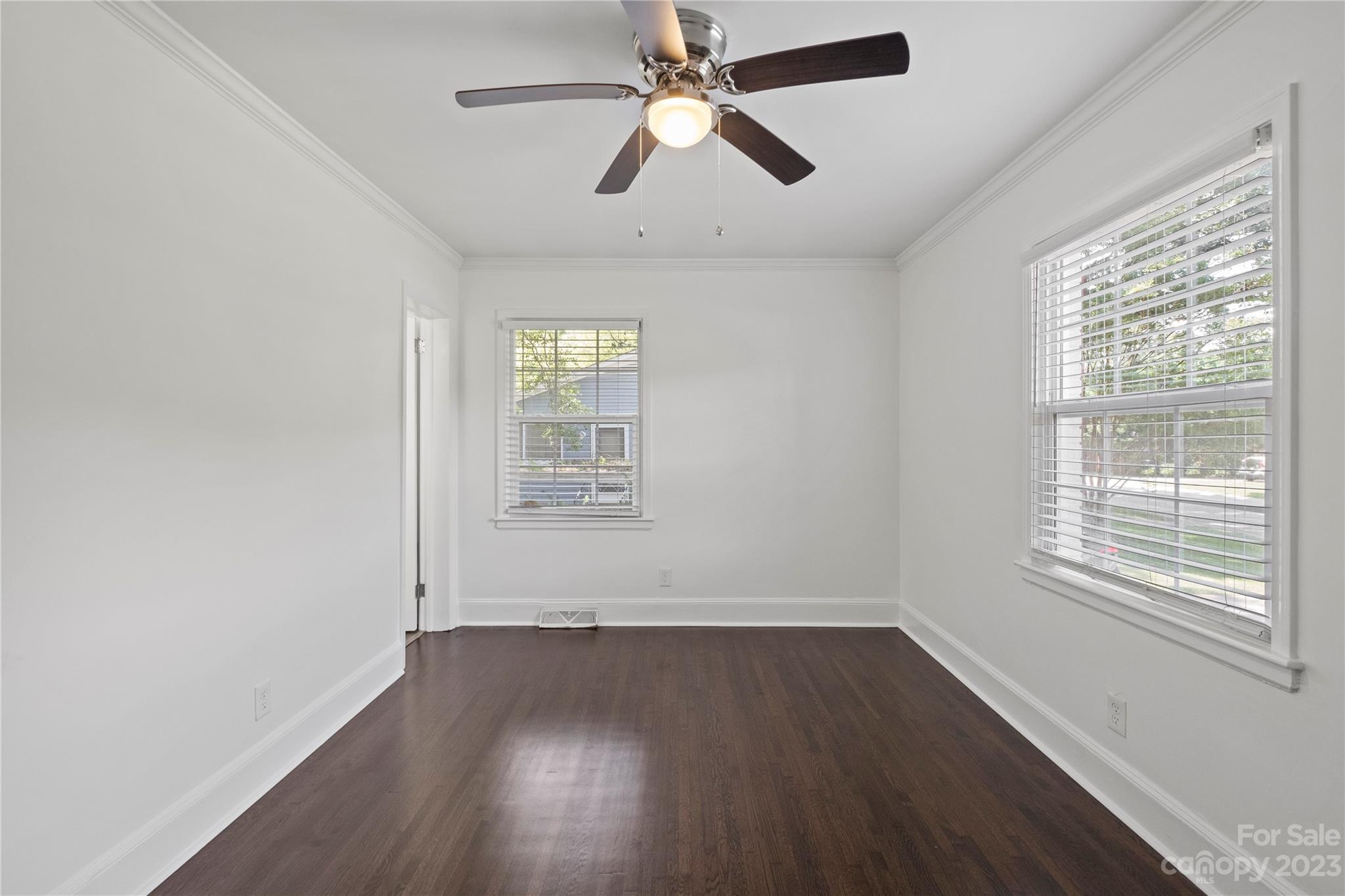 3522 Enfield Road Charlotte, NC 28205 - Photo 13 of 32 an empty room with wooden floor ceiling fan and windows