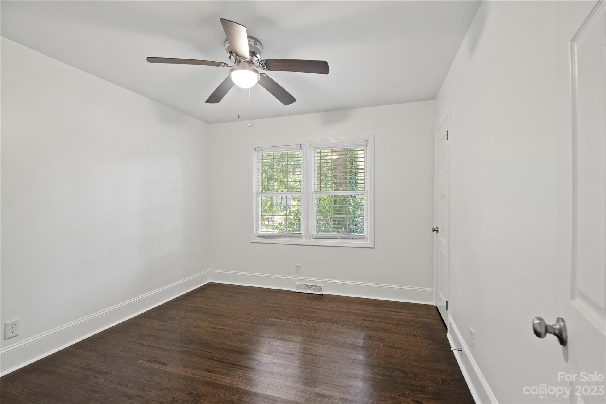 3522 Enfield Road Charlotte, NC 28205 - Photo 17 of 32 an empty room with wooden floor ceiling fan and windows