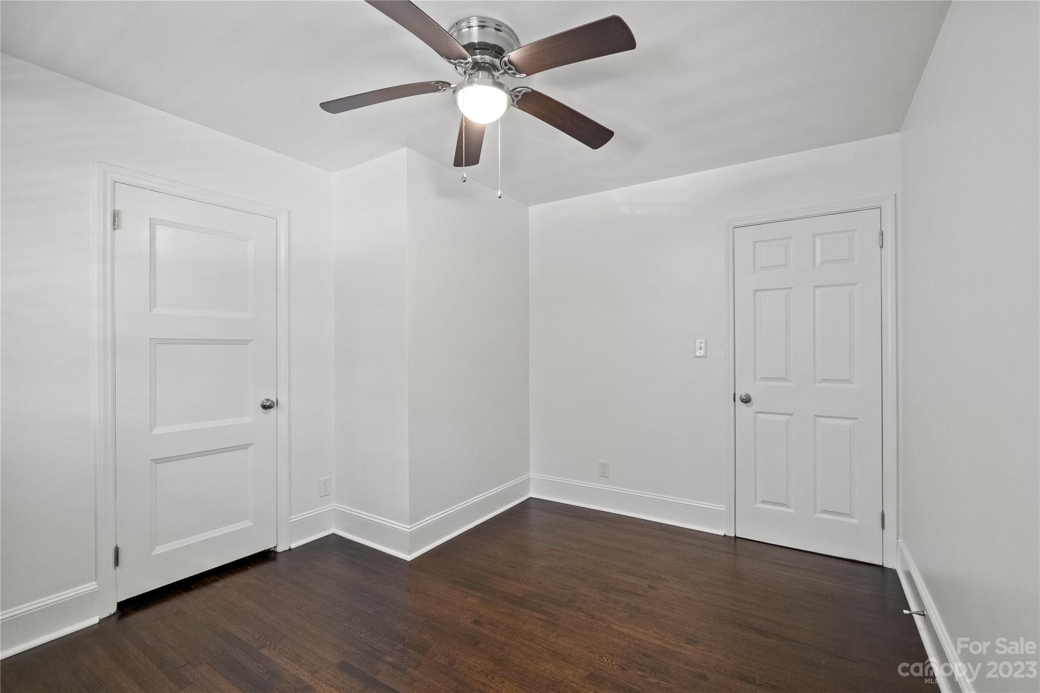 3522 Enfield Road Charlotte, NC 28205 - Photo 19 of 32 an empty room with wooden floor ceiling fan and windows