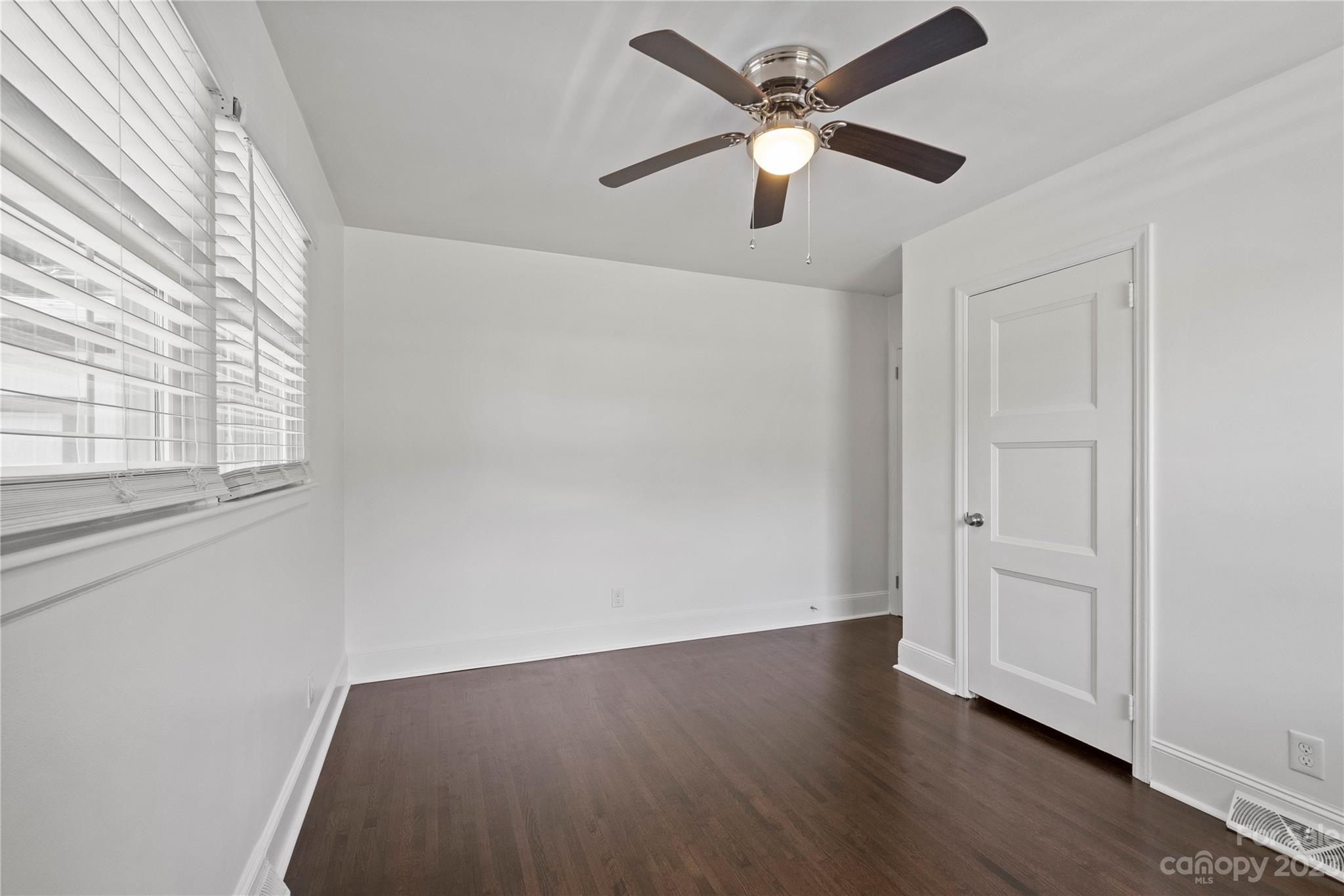 3522 Enfield Road Charlotte, NC 28205 - Photo 24 of 32 an empty room with wooden floor ceiling fan and windows