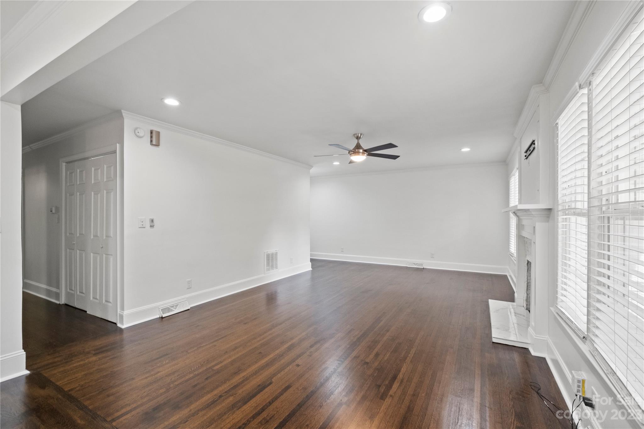 3522 Enfield Road Charlotte, NC 28205 - Photo 5 of 32 an empty room with wooden floor fan and windows