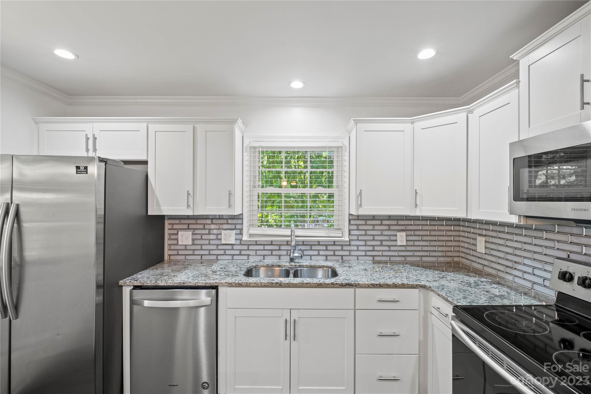 3522 Enfield Road Charlotte, NC 28205 - Photo 9 of 32 a kitchen with stainless steel appliances granite countertop a sink stove and cabinets