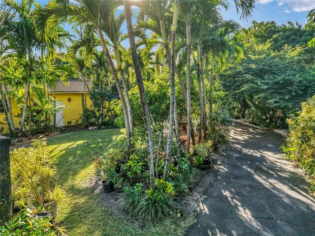 a living room with stainless steel appliances furniture a flat screen tv and a kitchen view