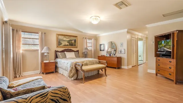 a bedroom with a large bed and chandelier