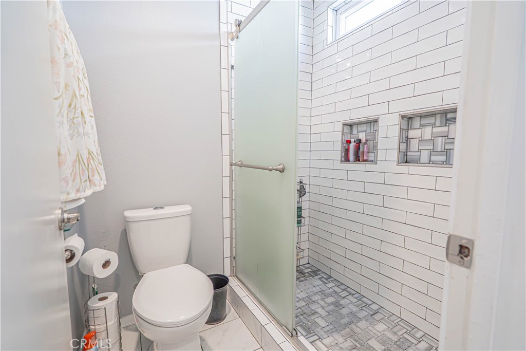 27738 Hyssop Lane Saugus, CA 91350 - Photo 25 of 43 a white toilet sitting next to a shower curtain