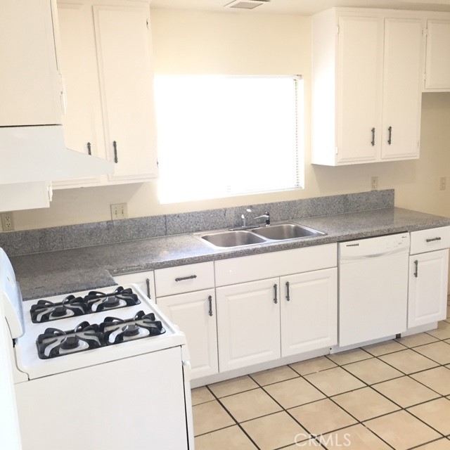13237 Mohawk Road Apple Valley, CA 92308 - Photo 5 of 21 a kitchen with granite countertop white cabinets and white appliances