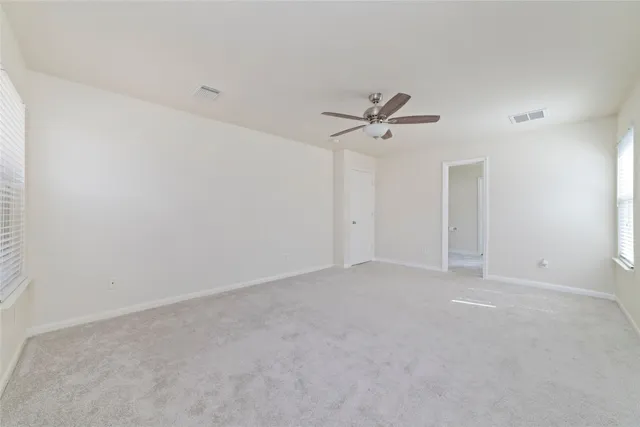 a view of an empty room with a ceiling fan