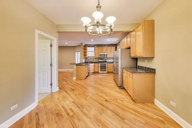 a kitchen with stainless steel appliances granite countertop a stove a sink and a refrigerator