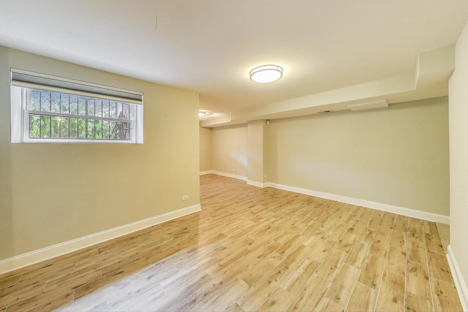 7730 North Paulina Street, Unit 1 Chicago, IL 60626 - Photo 36 of 59 a view of empty room with wooden floor and fan