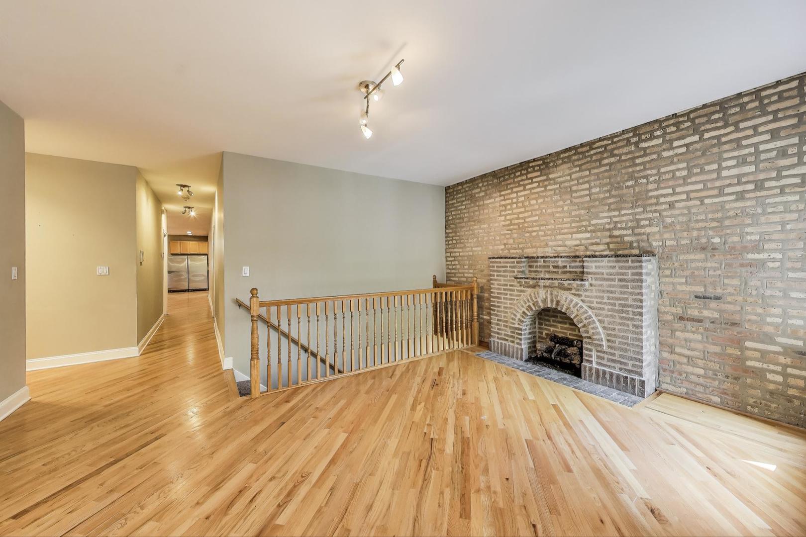 7730 North Paulina Street, Unit 1 Chicago, IL 60626 - Photo 6 of 59 a view of empty room with wooden floor and fireplace