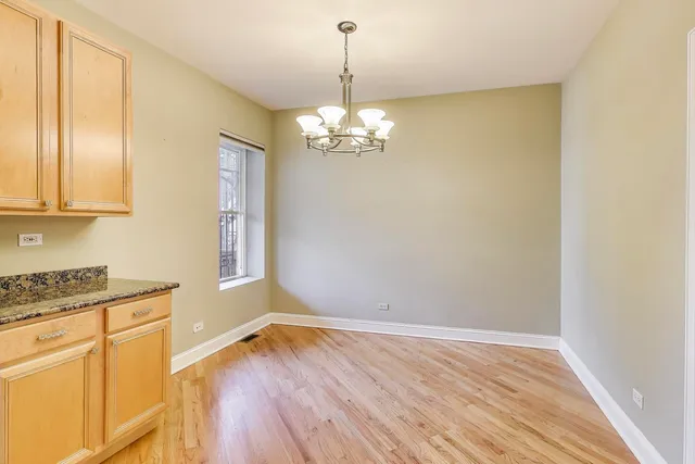 a view of a kitchen with wooden floor and a window