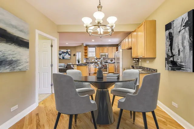 a view of a dining room with furniture a chandelier and wooden floor