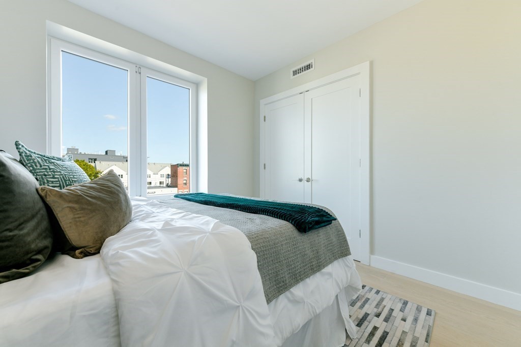 932 Broadway, Unit 212 Chelsea, MA 02150 - Photo 30 of 35 a bedroom with a bed and window