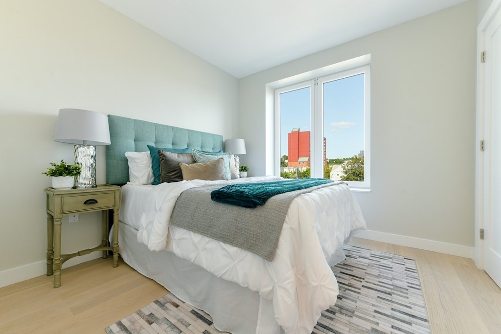 932 Broadway, Unit 212 Chelsea, MA 02150 - Photo 31 of 35 a bedroom with a bed and a window