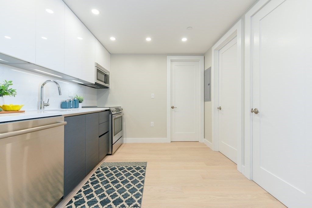 932 Broadway, Unit 212 Chelsea, MA 02150 - Photo 8 of 35 a kitchen with cabinets and window