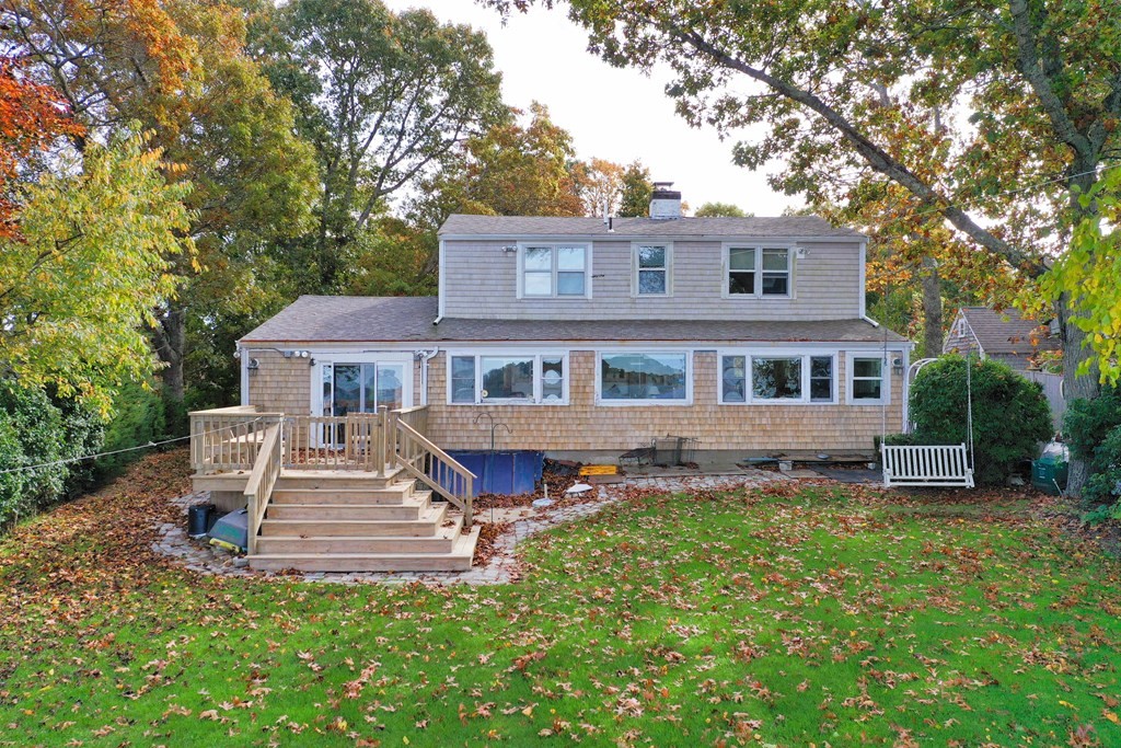 189 Tahanto Road Bourne, MA 02559 - Photo 2 of 24 a front view of a house with a garden and trees