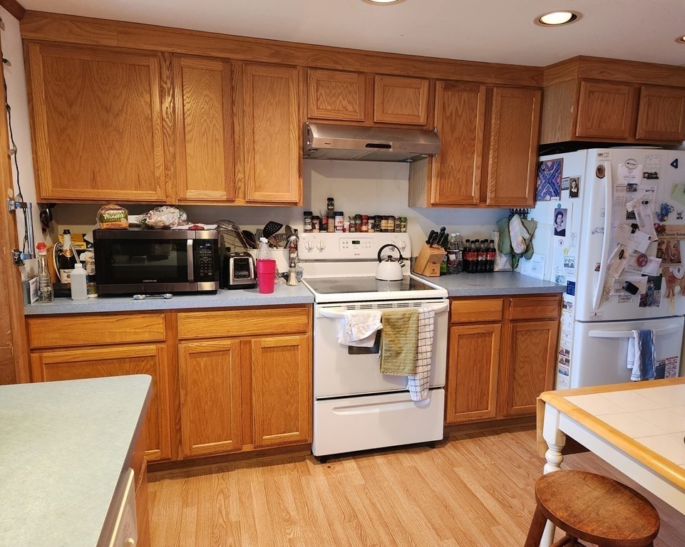 189 Tahanto Road Bourne, MA 02559 - Photo 7 of 24 a kitchen with stainless steel appliances a stove a sink and white cabinets
