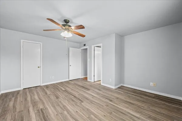 a view of a room with wooden floor and a ceiling fan