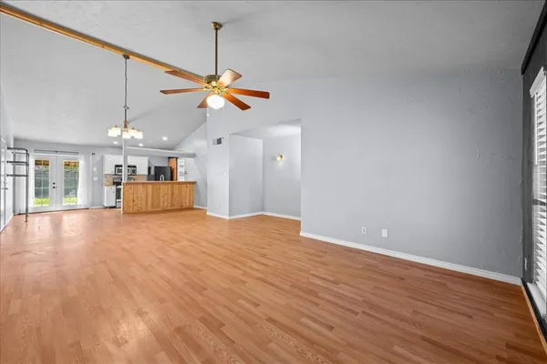 a view of a kitchen with wooden floor and a ceiling fan
