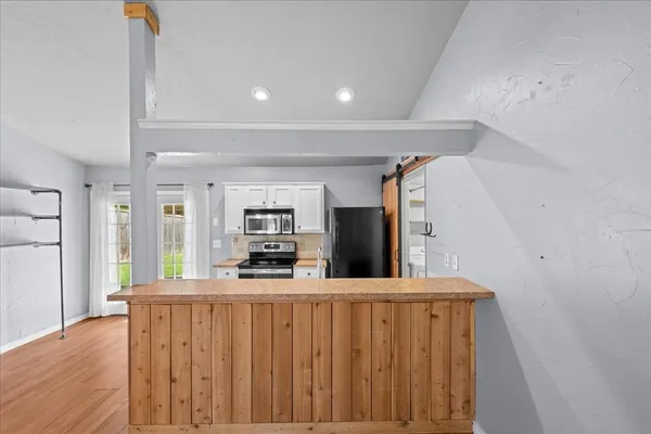 a kitchen with stainless steel appliances a counter top space and cabinets