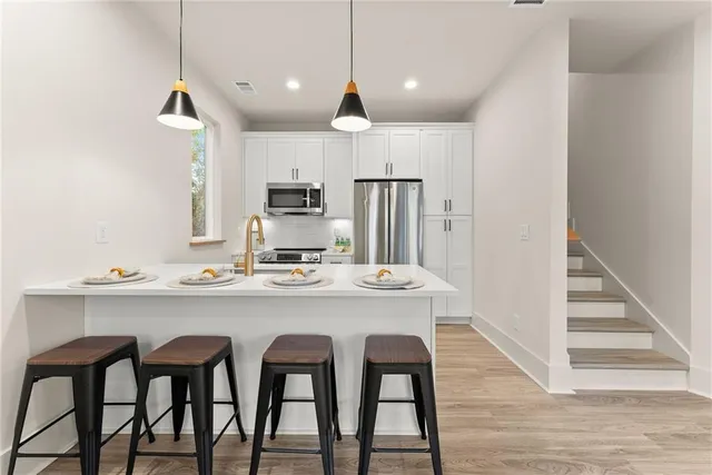 a kitchen with kitchen island wooden cabinets and refrigerator