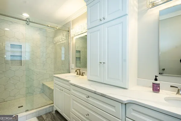 a bathroom with a shower and a sink a mirror