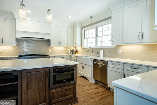a kitchen with a sink stove top oven and cabinets