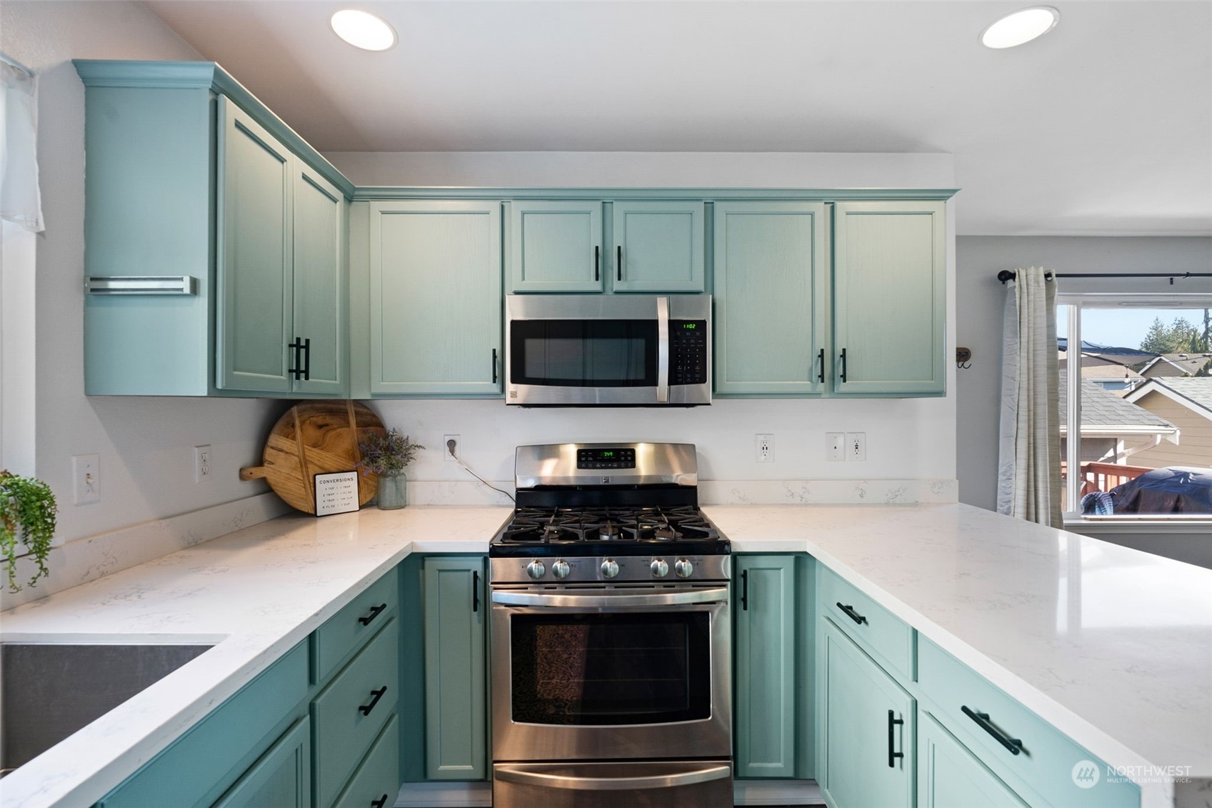16887 Copper Mountain Road Southeast Monroe, WA 98272 - Photo 11 of 34 a kitchen with stainless steel appliances a stove a sink and a microwave