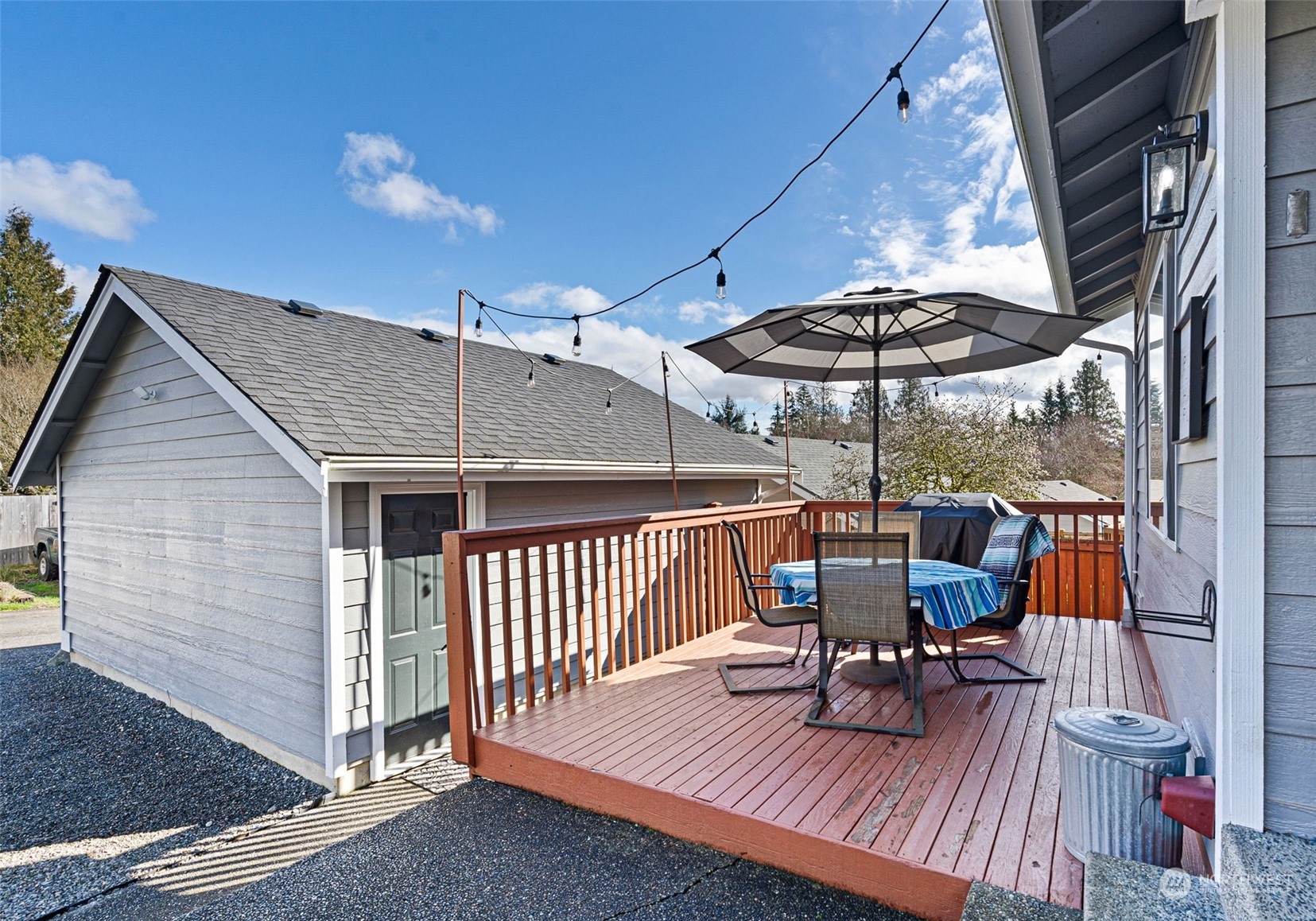 16887 Copper Mountain Road Southeast Monroe, WA 98272 - Photo 25 of 34 a view of a roof deck with table and chairs under an umbrella with wooden floor