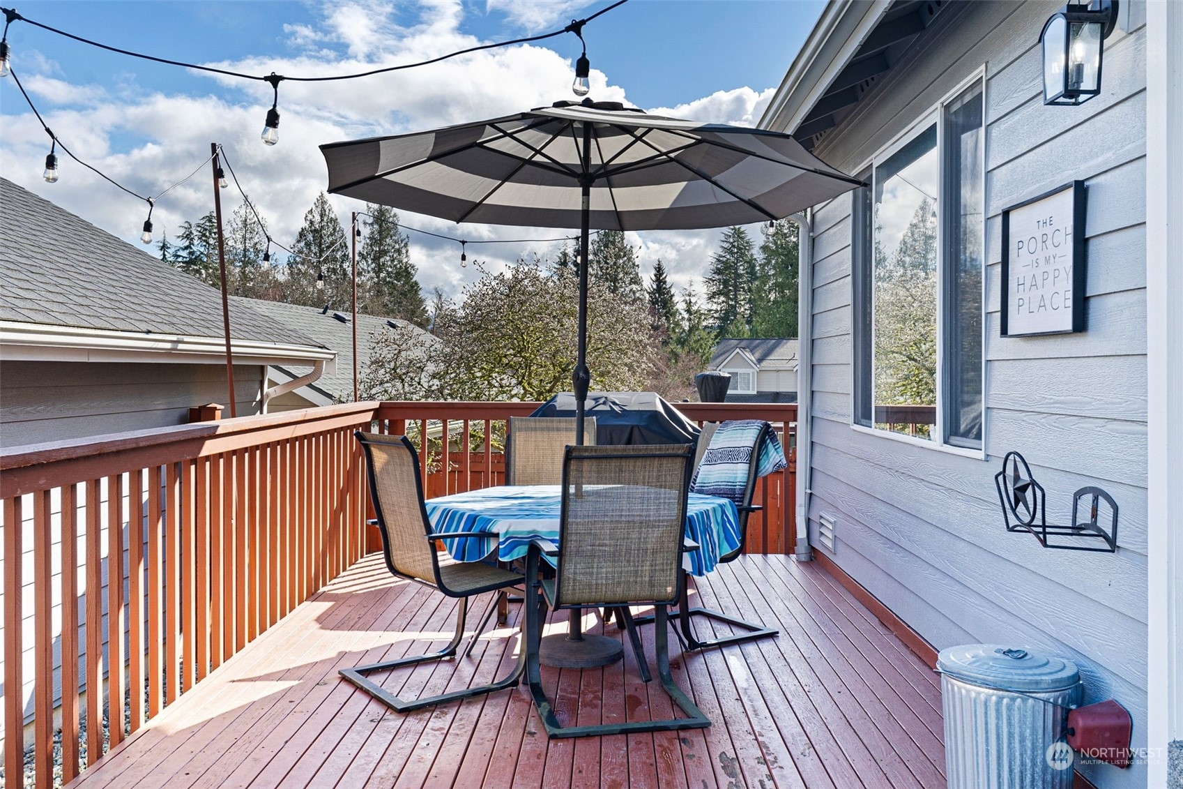 16887 Copper Mountain Road Southeast Monroe, WA 98272 - Photo 26 of 34 a view of a patio with table and chairs under an umbrella with wooden floor