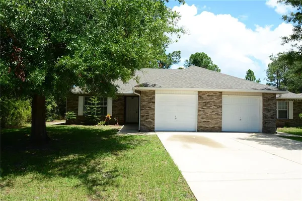 a front view of a house with yard and trees