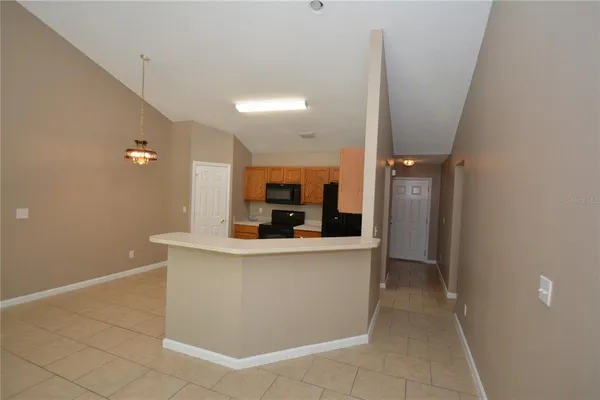 a view of living room with stainless steel appliances wooden floor and chair