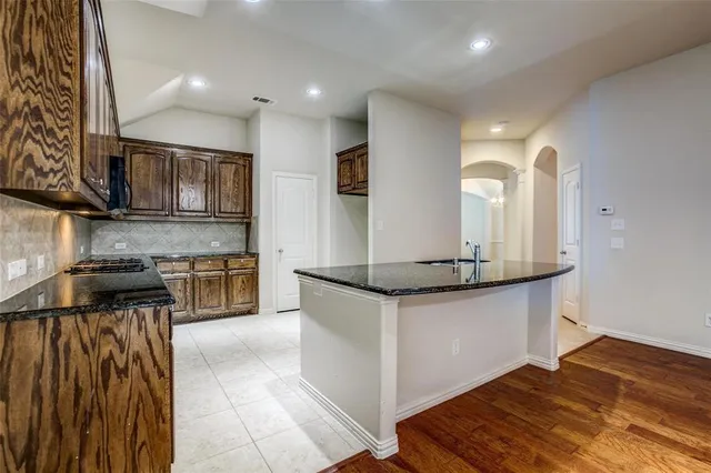 a kitchen with stainless steel appliances granite countertop a sink and a stove