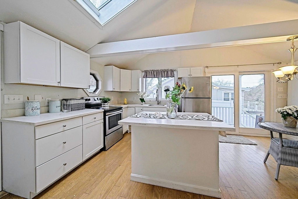 21 Hillside Road Plymouth, MA 02360 - Photo 30 of 39 a kitchen with kitchen island granite countertop a sink cabinets and wooden floor