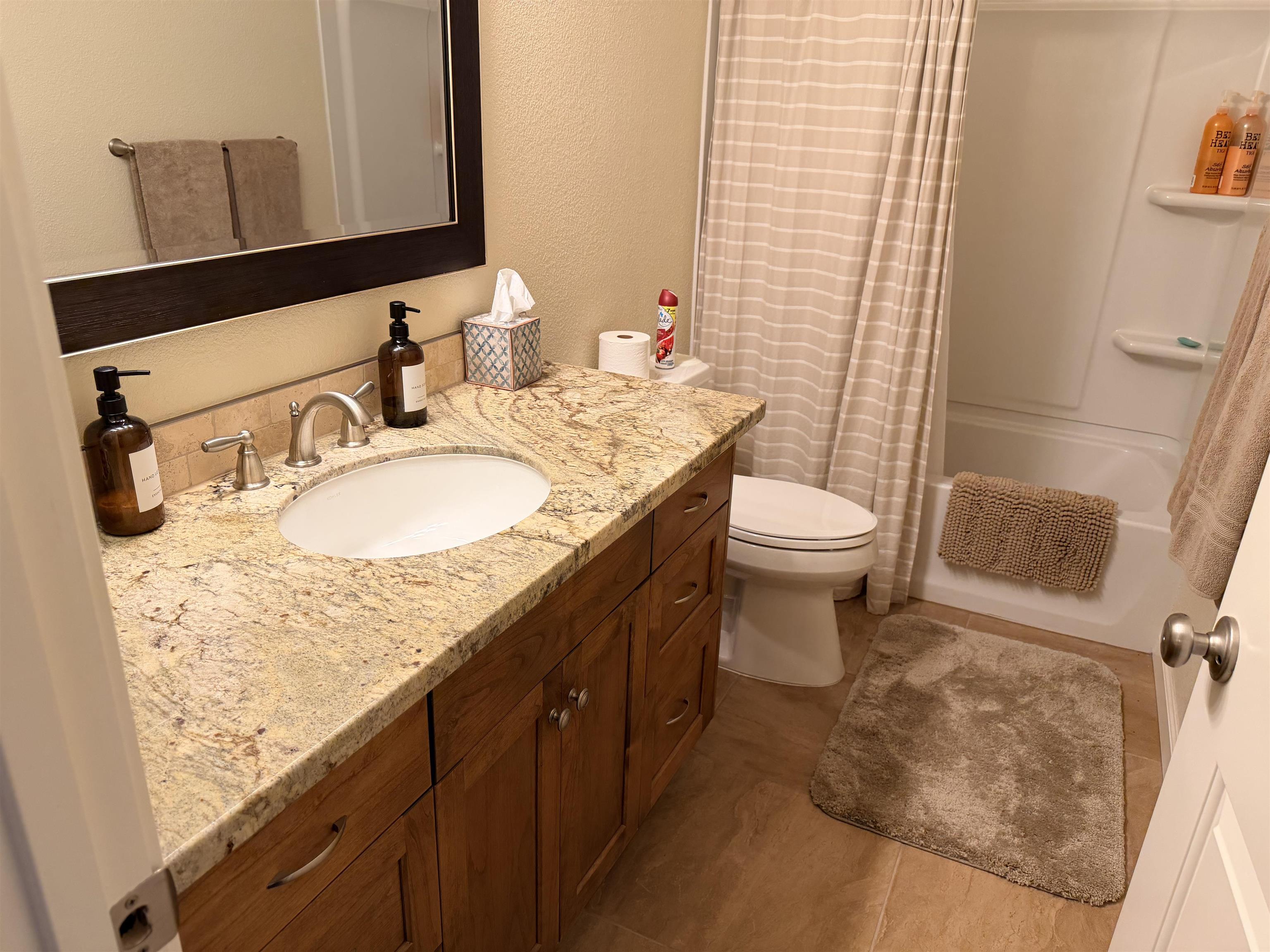 831 Timber Ridge Road Lake Almanor, CA 96137 - Photo 19 of 36 a bathroom with a granite countertop sink toilet and mirror