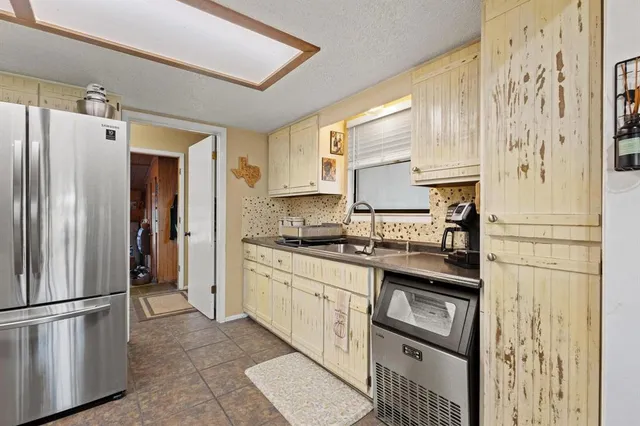 a kitchen with stainless steel appliances granite countertop a refrigerator and a sink