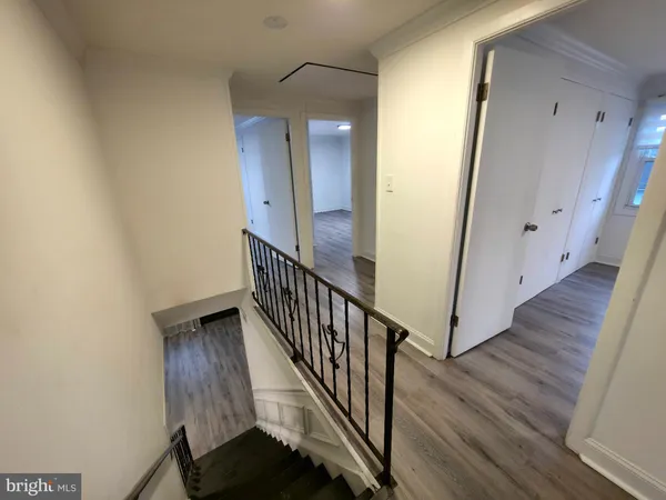 a view of a hallway with wooden floor and staircase