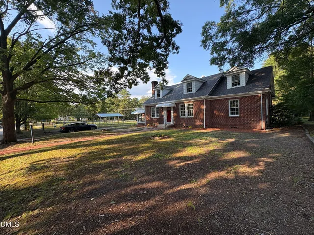 a view of a house with a big yard next to a road