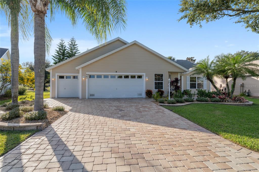 967 Livingston Loop The Villages, FL 32162 - Photo 2 of 62 a view of a house with a yard and potted plants