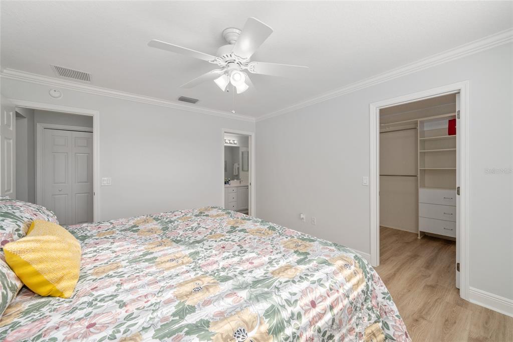 967 Livingston Loop The Villages, FL 32162 - Photo 21 of 62 a bedroom with a bed and a chandelier