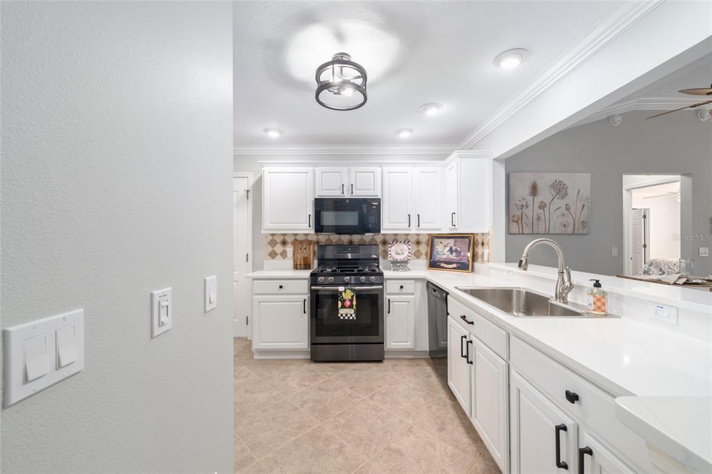 967 Livingston Loop The Villages, FL 32162 - Photo 6 of 62 a kitchen with cabinets stainless steel appliances and a counter top space