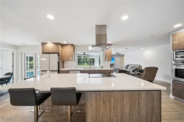 a kitchen with stainless steel appliances kitchen island granite countertop a sink and cabinets