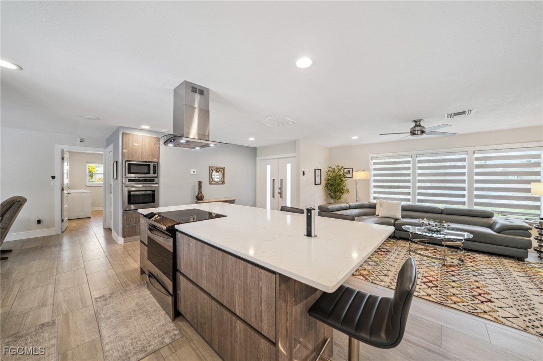 422 Coral Drive Cape Coral, FL 33904 - Photo 17 of 43 a kitchen with stainless steel appliances kitchen island granite countertop a sink and cabinets