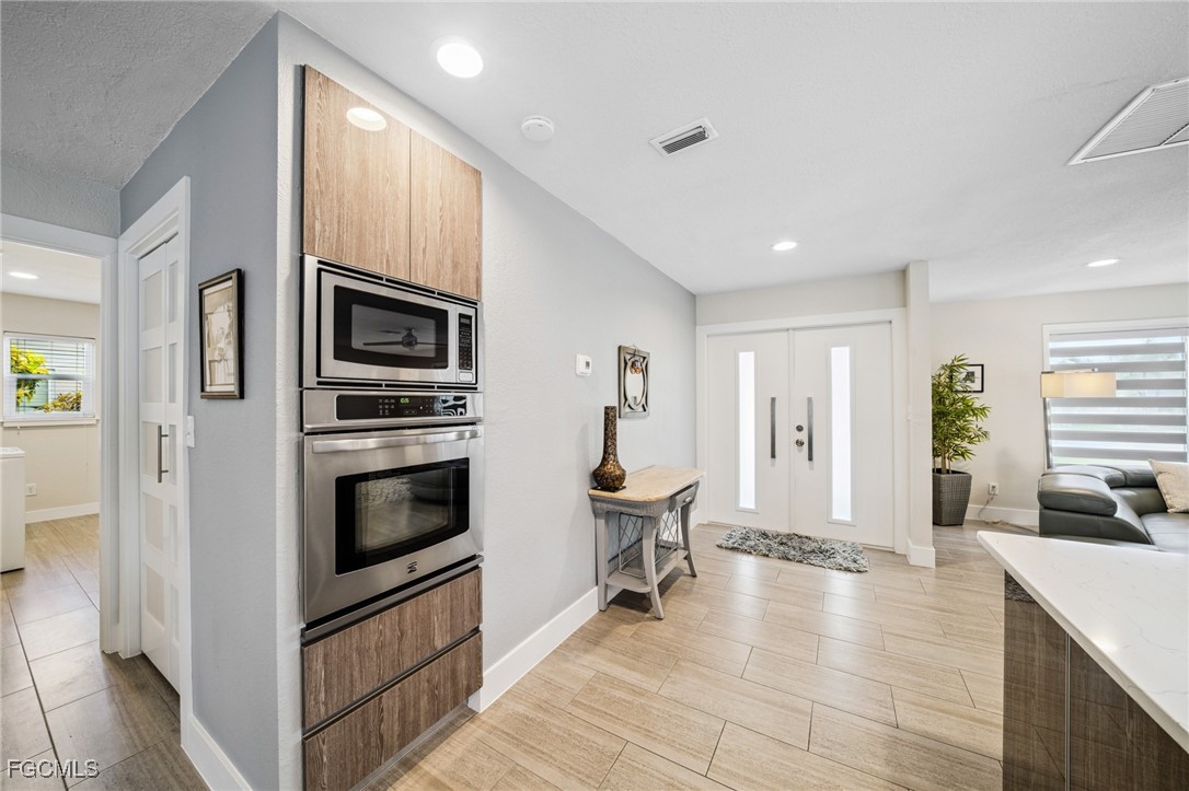 422 Coral Drive Cape Coral, FL 33904 - Photo 18 of 43 a kitchen with stainless steel appliances a stove a microwave and a refrigerator